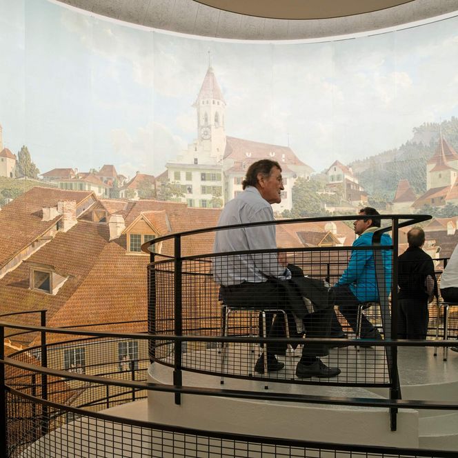 Die Besucher des Thun Panoramas lassen sich von dem Panorama-Bild beeindrucken. 