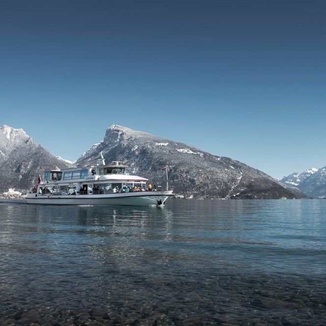 Schiff auf dem blauen Thunersee mit verschneitem Niederhorn im Hintergrund