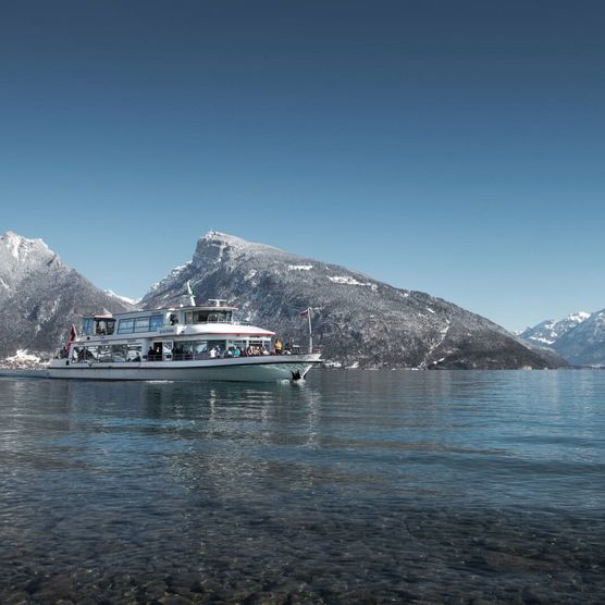 Schiff auf dem blauen Thunersee mit verschneitem Niederhorn im Hintergrund