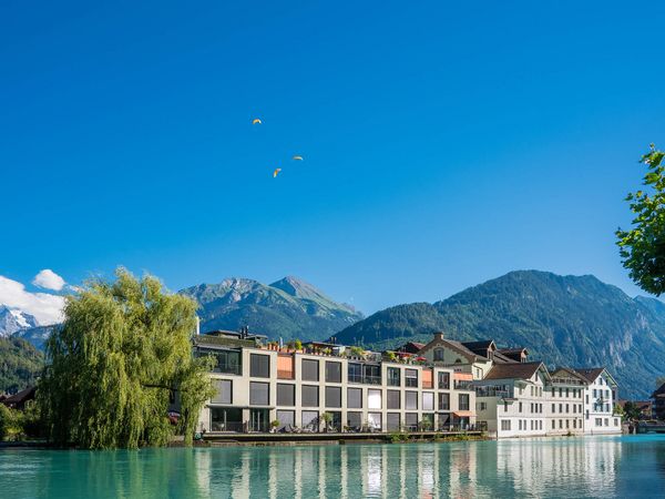 Interlaken an der Aare mit Paraglidern im Hintergrund