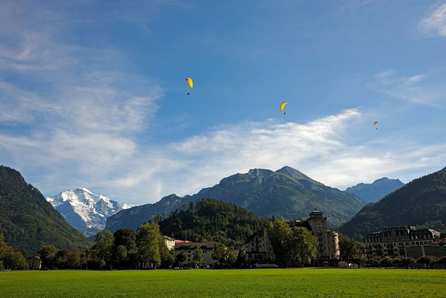 Vor der imposanten Kulisse der Jungfrau kreisen Gleitschirme über Interlaken
