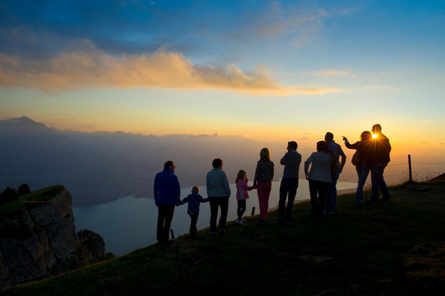 Eine Gruppe geniesst den farbenfrohen Sonnenuntergang auf dem Niederhorn