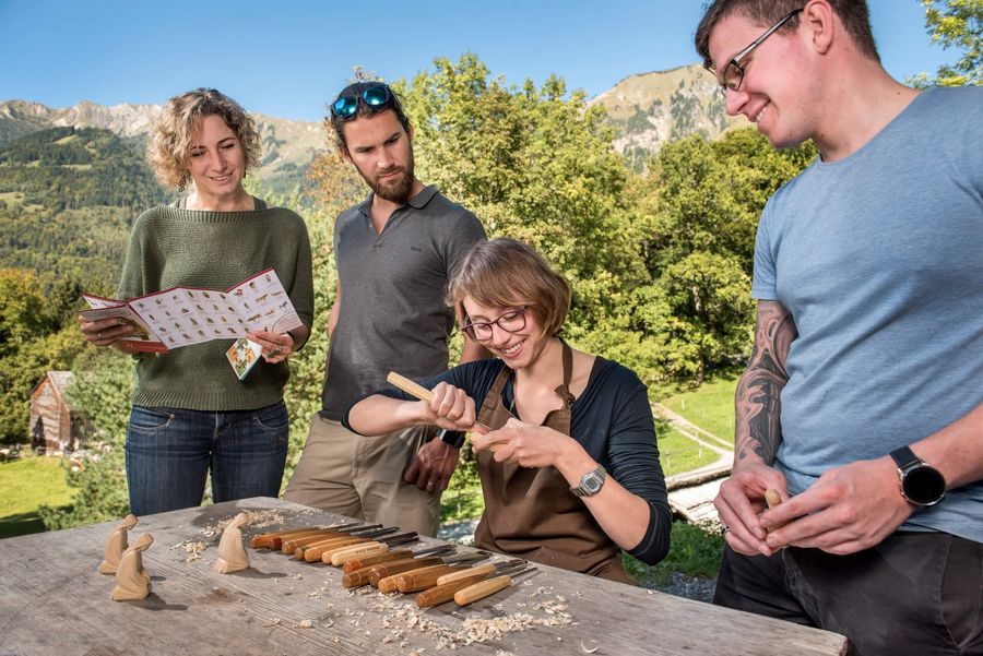 Museumsbesucher erlernen ein traditionelles Schweizer Handwerk im Freilichtmuseum Ballenberg