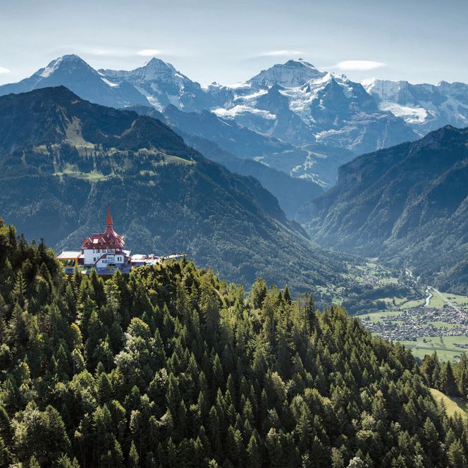 Blick auf das Restaurant Harder Kulm mit Eiger, Mönch und Jungfrau im Hintergrund