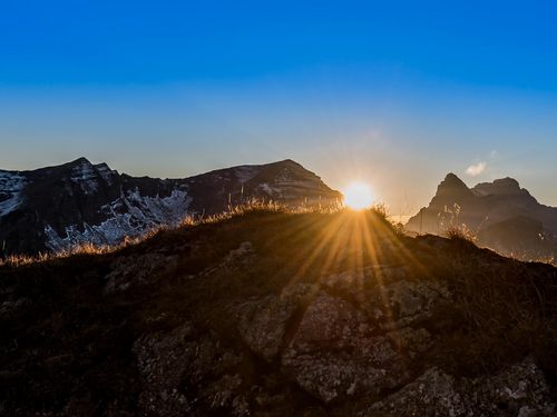 Sonnenuntergang zwischen zwei Berggipfeln im Naturpark Diemtigtal