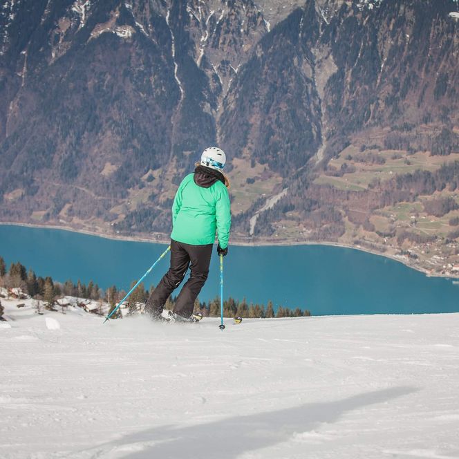 Skifahrer im Skigebiet auf der Axalp mit Blilcka uf den türkisen Brienzersee und Brienz